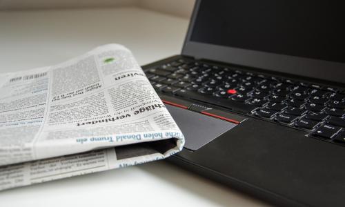 Eine Zeitung und ein Laptop auf einem TIsch